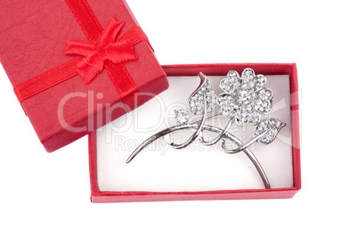 Beautiful silver brooch in a red gift box, isolated on white