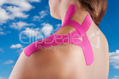 Therapy with kinesio tex tape against a blue sky