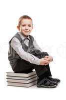 Smiling child boy sitting on reading books