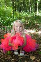 Sad little girl in fairy costume in a forest