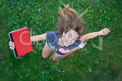 Girl with red laptop jumping up from joy