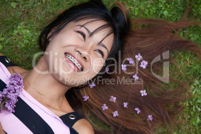 Thai womanwith a big smile laying on the grass