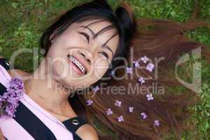 Thai womanwith a big smile laying on the grass