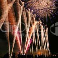 Fireworks in the amusement park with people in front