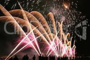 Fireworks in the amusement park with people in front