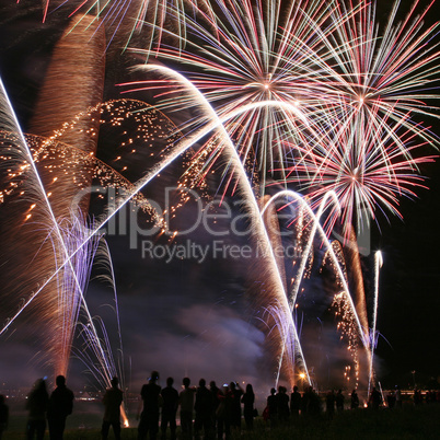 Fireworks in the amusement park with people in front