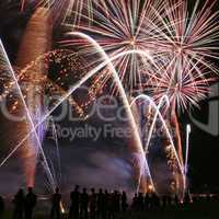 Fireworks in the amusement park with people in front