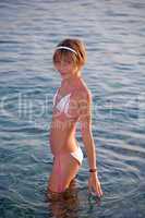 Teenage girl in bikini entering the sea