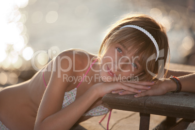 Teenage girl resting on a staircase by the sea