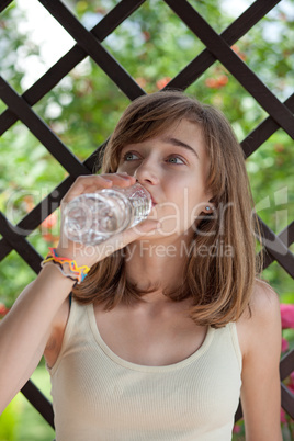 Teenage girl drinking water from the bottle