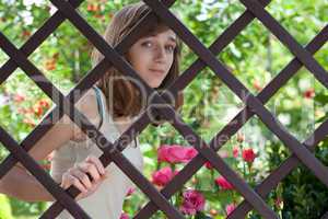 Teenage girl behind a wooden fence