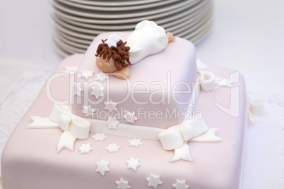 pink christening cake with little angel on top