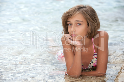 Teenage girl laying in the sea wate