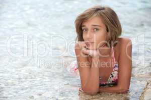 Teenage girl laying in the sea wate