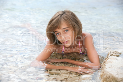 Teenage girl laying in the sea water