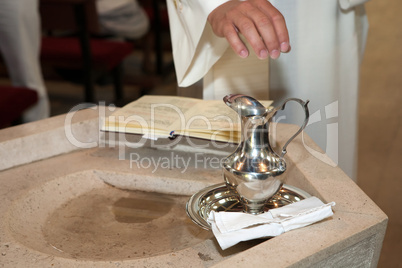 Minister blessing the holy water before the baptism ceremony