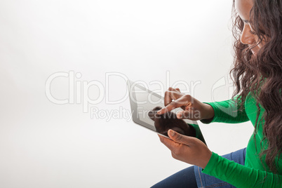 Das farbige Mädchen arbeitet mit einem Tablett-PC