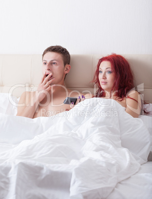 Surprised young couple in bed