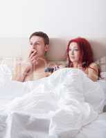 Surprised young couple in bed