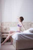 Charming slim woman posing in purple lingerie