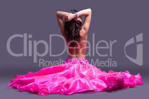 topless dancer in pink costume sitting on floor