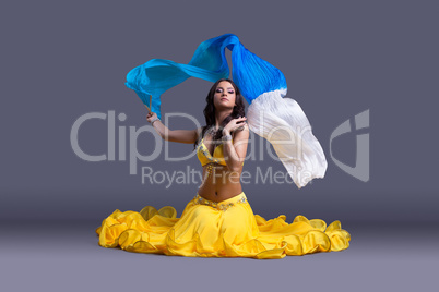 Pretty dancer in yellow costume sitting on floor