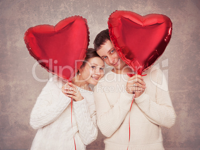 Young couple with balloons in the form of heart