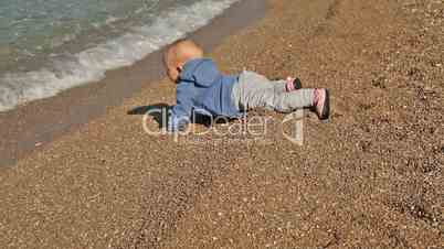 Baby crawl on the beach toward sea