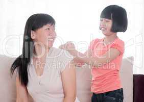 Asian child doing shoulder massage to her mother