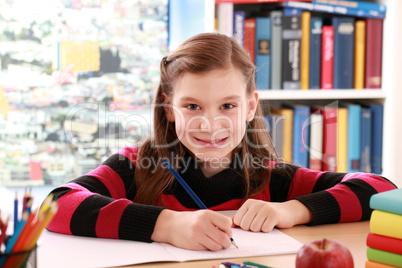 Mädchen macht Hausaufgaben und lächelt