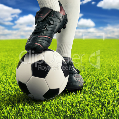 Ball und Füße eines Fußballers in lässiger Pose