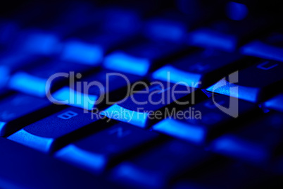 Computer keyboard in blue light.