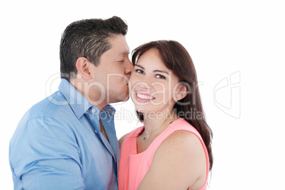 Close-up portrait of woman being affectionately kissed by her hu