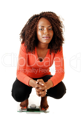 Girl crouching on scale.