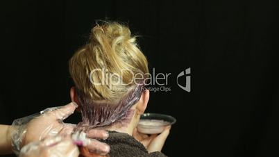 Woman at hairdresser coloring her hair