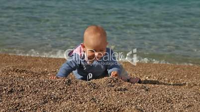 Baby playing and crawling on the beach