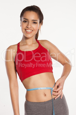 woman measuring her waist with a smile
