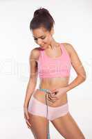 slim woman measuring her waist