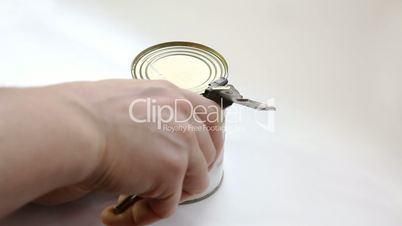 Man opening metal can with tomato sauce with vintage key