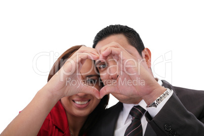 Happy couple in love showing heart with their fingers