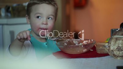 Two year old boy is eating fish soup from the plate. Clip three.