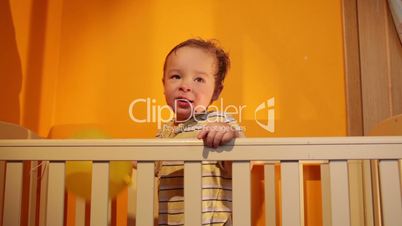Boy plays with balloon in the playpen.