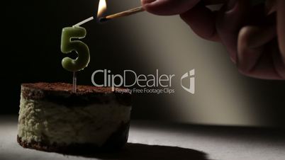Candle five in tiramisu cake.