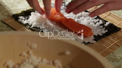 Making sushi rolls with salmon and philadelphia cheese.