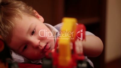Two year old boy plays with toy trucks.