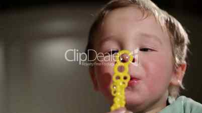 Two year old boy blowing soap bubbles.
