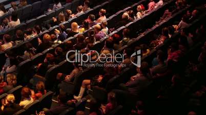 People at the theatre performance. Shot from back. High angle.