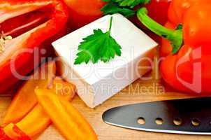 Feta cheese with a knife and vegetables