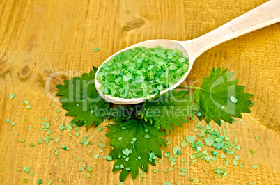 Salt green in a spoon with a nettle on the board