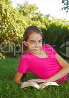 Teen girl reading the Bible outdoors